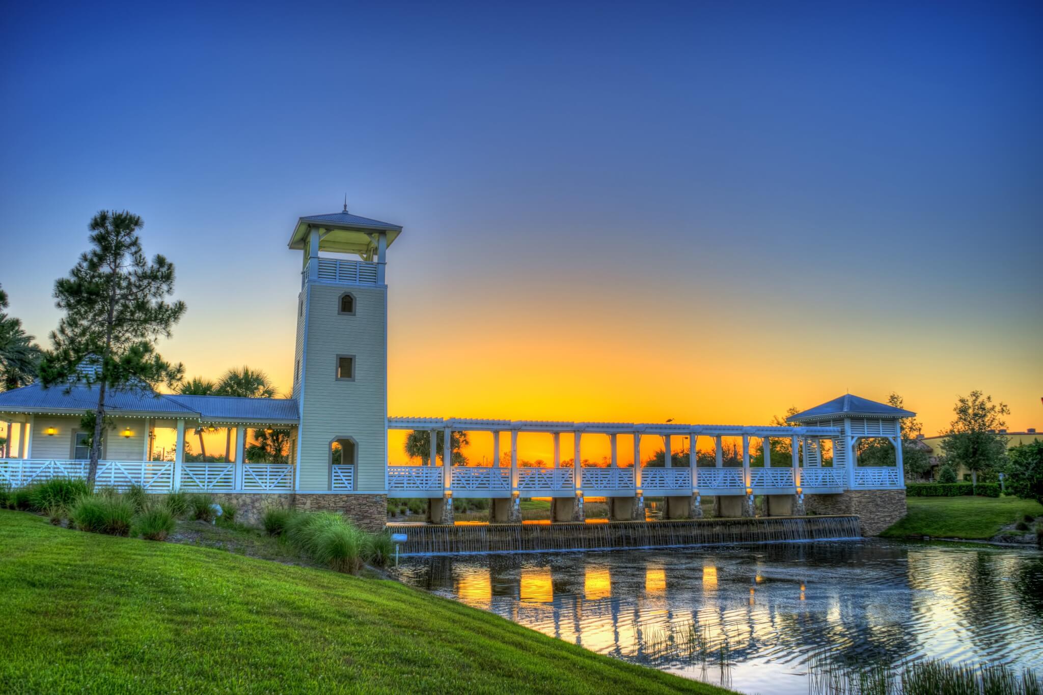 a bridge over a body of water with a tower and grass