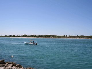 a boat moving across the Fort Pierce Inlet. 