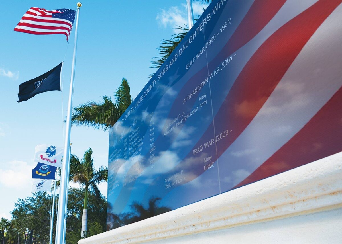 An American flag in front of a war memorial in St. Lucie.