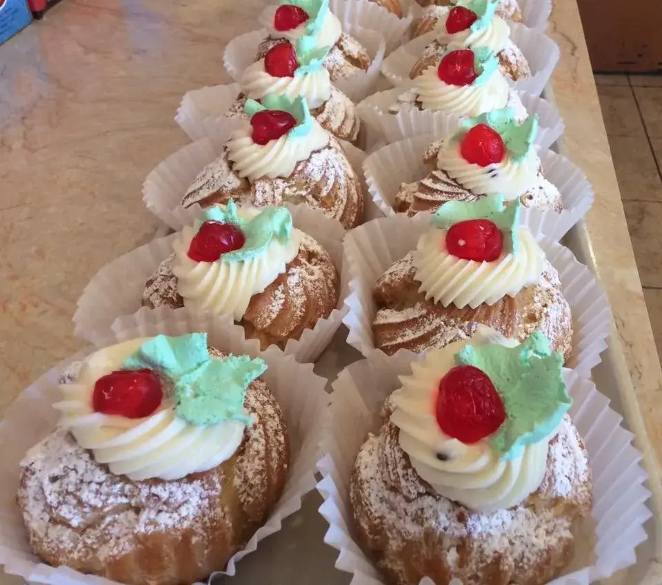 A tray of pastries topped with whipped cream and cherries in St. Lucie.